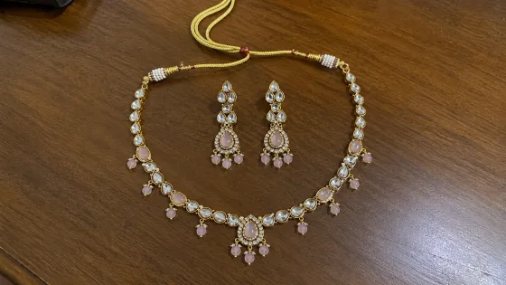 The same necklace and earrings photographed on a wooden table before being used in Monoshoot